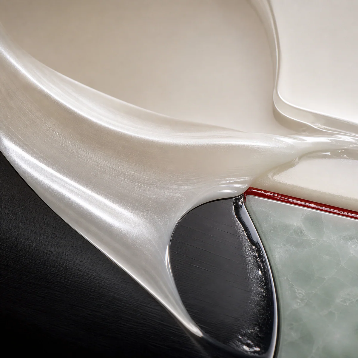 Pearl milk texture over black, stone, and red seam surfaces