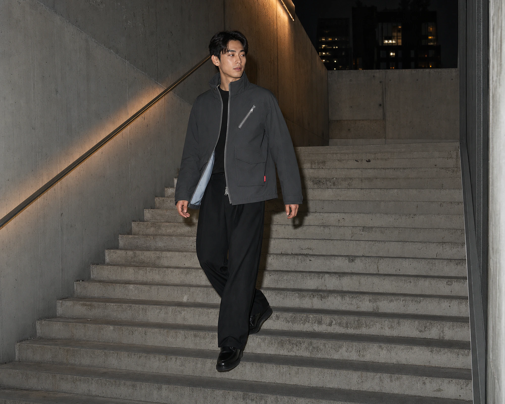 콘크리트 계단을 내려오는 RELAY JACKET 착용 모델