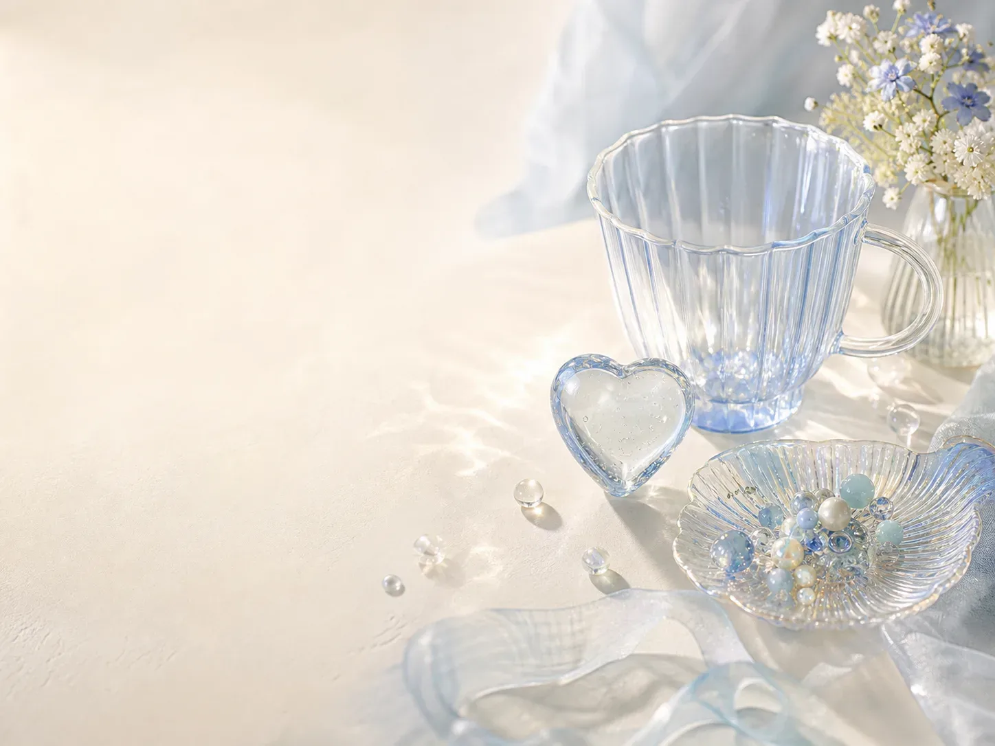 Blue glass cup, heart object, and shell tray