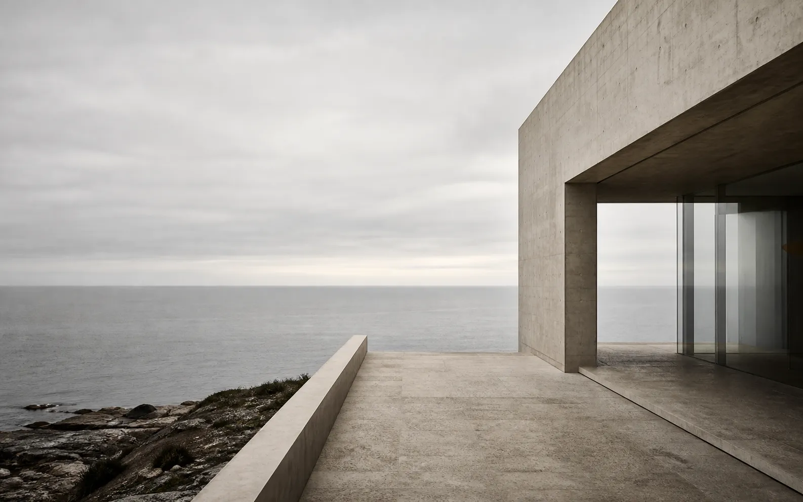 Concrete coastal pavilion overlooking a quiet ocean horizon