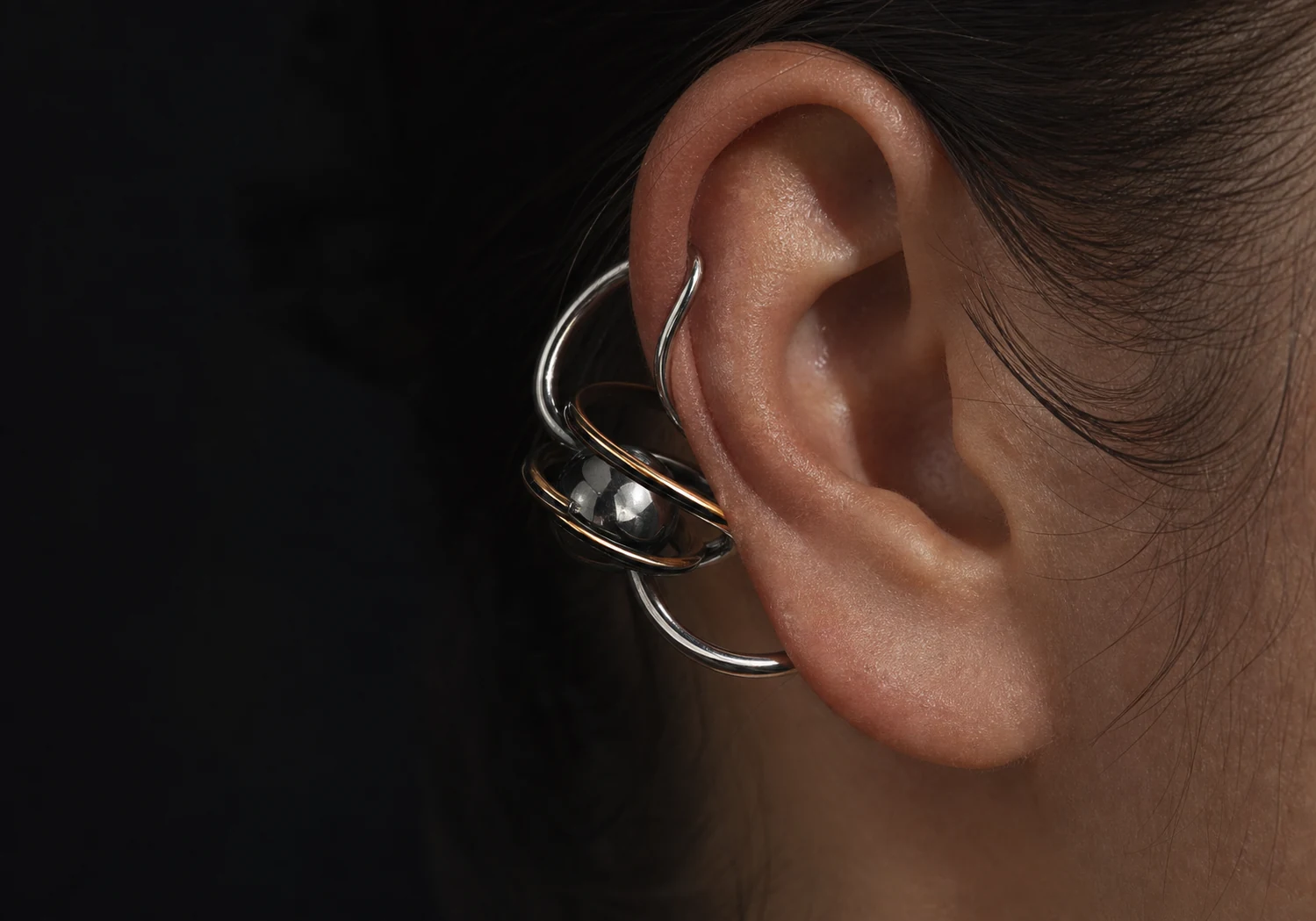Orbit shaped ear cuff worn on an ear.