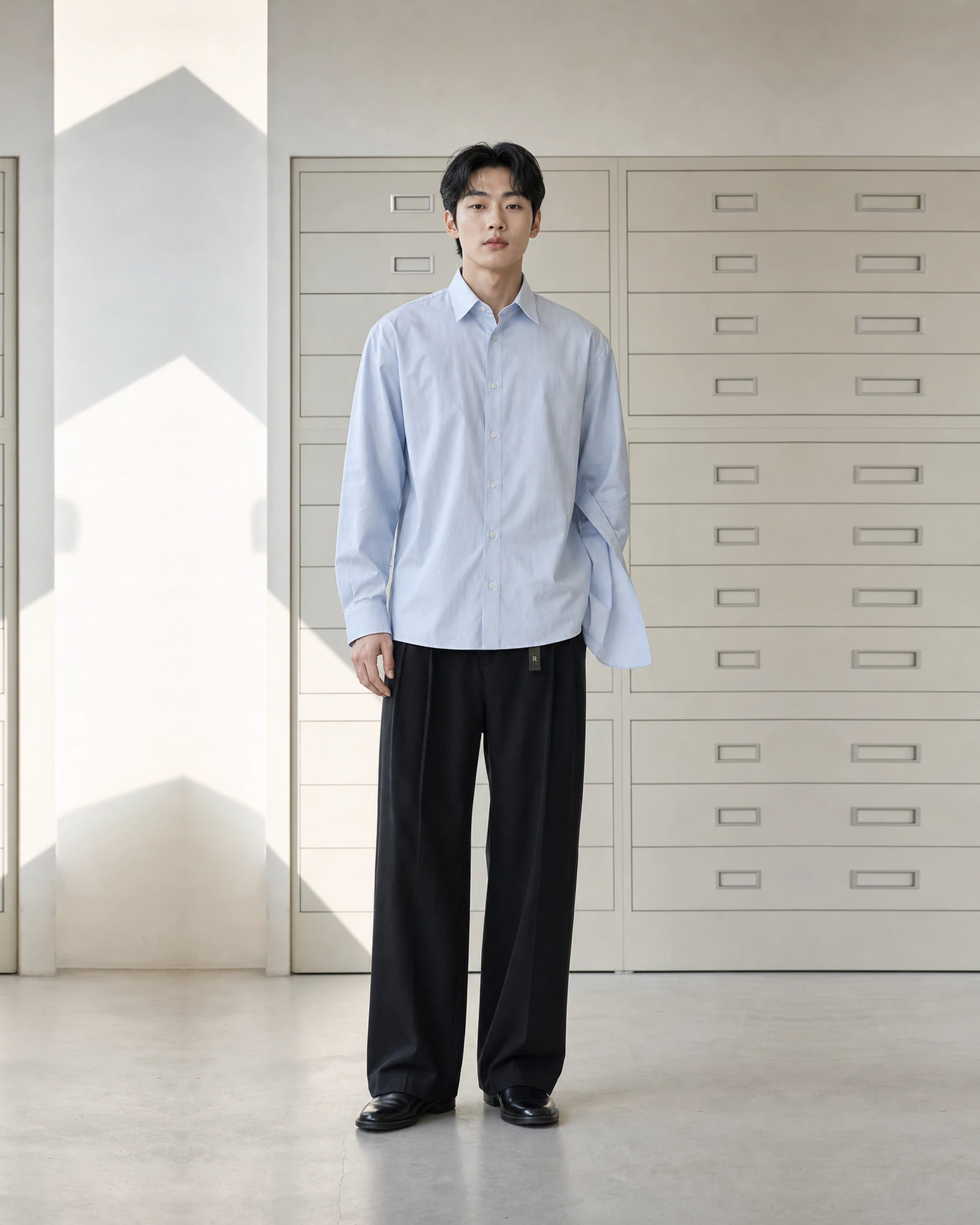 FOLD SHIRT와 검은 TAB TROUSER를 입은 모델